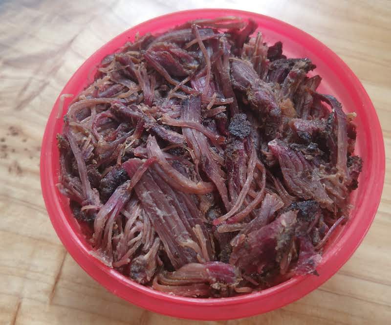 Shredded beef rib compacted into tupperware